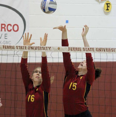 Defeating Hillsdale: FSU senior middle hitter Mallory Kopa (left) and FSU freshman middle hitter Courtney Rehm (right) reach to return a ball during the Hillsdale game on Sept. 24. The Bulldogs defeated the nationally-ranked Chargers 3-0, bringing the 2011 overall record to 11-1. Photo By: Brock Copus | Multimedia Editor