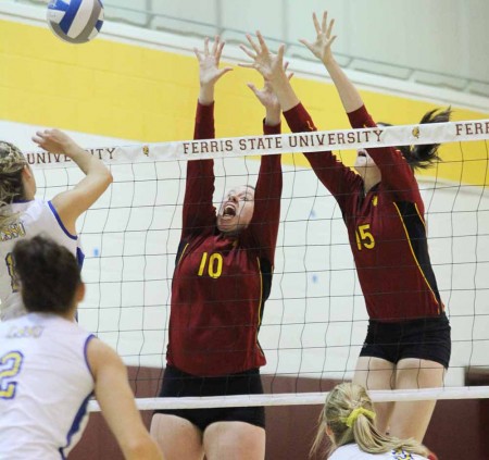 Stopping LSSU: Lindsey Miller, junior middle hitter, and Courtney Rehm, freshman middle hitter, reach for the ball during the match against LSSU on Sept. 17. The Bulldogs defeated Lake Superior State 3-0. Photo By: Brock Copus | Multimedia Editor