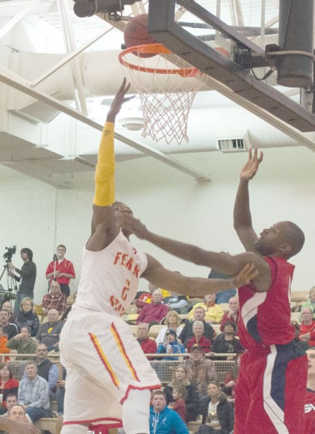 Putting it In: Ferris redshirt freshman guard Milton Cribbs makes a lay-up over a Saginaw Valley State defender. Ferris dropped its regular season finale against Grand Valley State 81-73. Photo By: Eric Trandel | Photographer