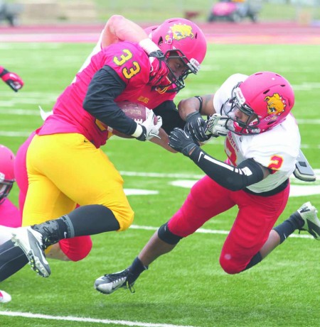 Spring Scrimmage: Freshman linebacker Jamel Lockett of the Red Team carries the ball against White Team senior defenseman William Miles in the Annual Crimson and Gold Spring Football Game. Photo By: Brock Copus | Multimedia Editor