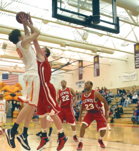 Ferris sophomore center Jared Stolicker goes up for a shot against Lewis defenders during the 2012-2013 season. The Ferris basketball team will start its season Oct. 24 against Madonna. Torch File Photo