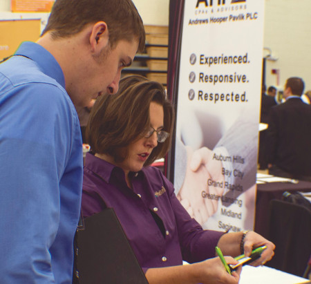 Adam Helminiak, graphic media management senior, sets up an interview for an internship with MasterTag during the career fair. Photo By: Eric Trandel | Photo Editor