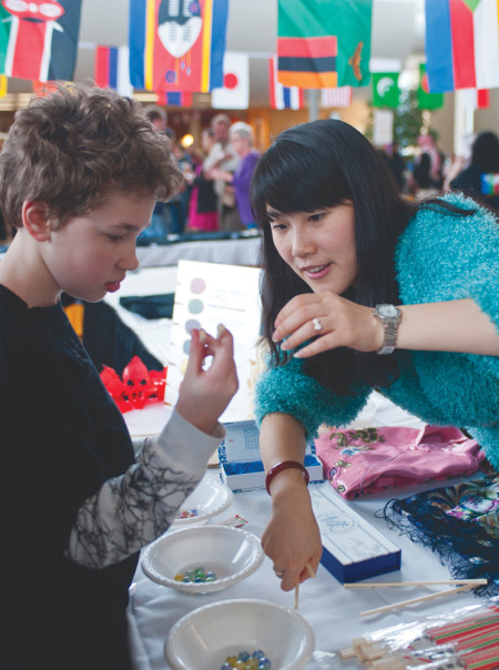 Every year, members of Big Rapids and Ferris are invited to experience food, dance and other traditions of the various cultures represented by the many international students at Ferris. Here a young boy learns how to use chopsticks at the China booth. Photo By: Tori Thomas | Photographer