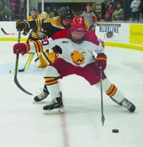 Sophomore forward Gerald Mayhew fends off a Michigan Tech defender in the offensive zone.