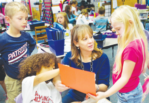 Kindergarten teacher Teresa Reaugh, center, works with her students, in her classroom on Oct. 28, 2014, at Holly Ridge Elementary School in Holly Springs, N.C. FSUS is the Kindergarten of college.