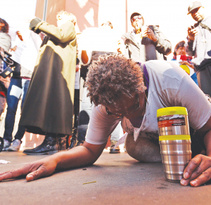 Suzette Shaw, 50, screaming “You can’t kill” lays down on Tuesday, March 3, 2015, at the site where a homeless man was killed by LAPD officers.