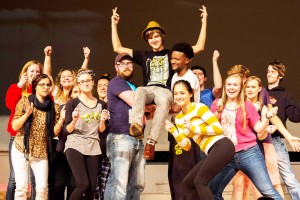 The cast of “Dirty Rotten Scoundrels” raises up Ferris pre-pharmacy junior Adam Juranda as he rehearses his big number. 