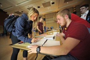 Students on a college campus stop by a table to ensure they have been registered to vote. To register to vote in Michigan, just visit a branch of the Secretary of State and fill out a voter registration form.