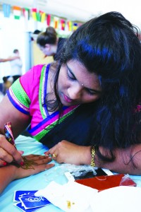 Above, Jyotsna Uddavolu applies henna to students at Ferris’ Diwali celebration.