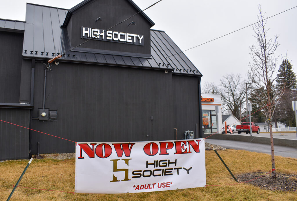 High Society is pictured with a "NOW OPEN" sign in front of the building.